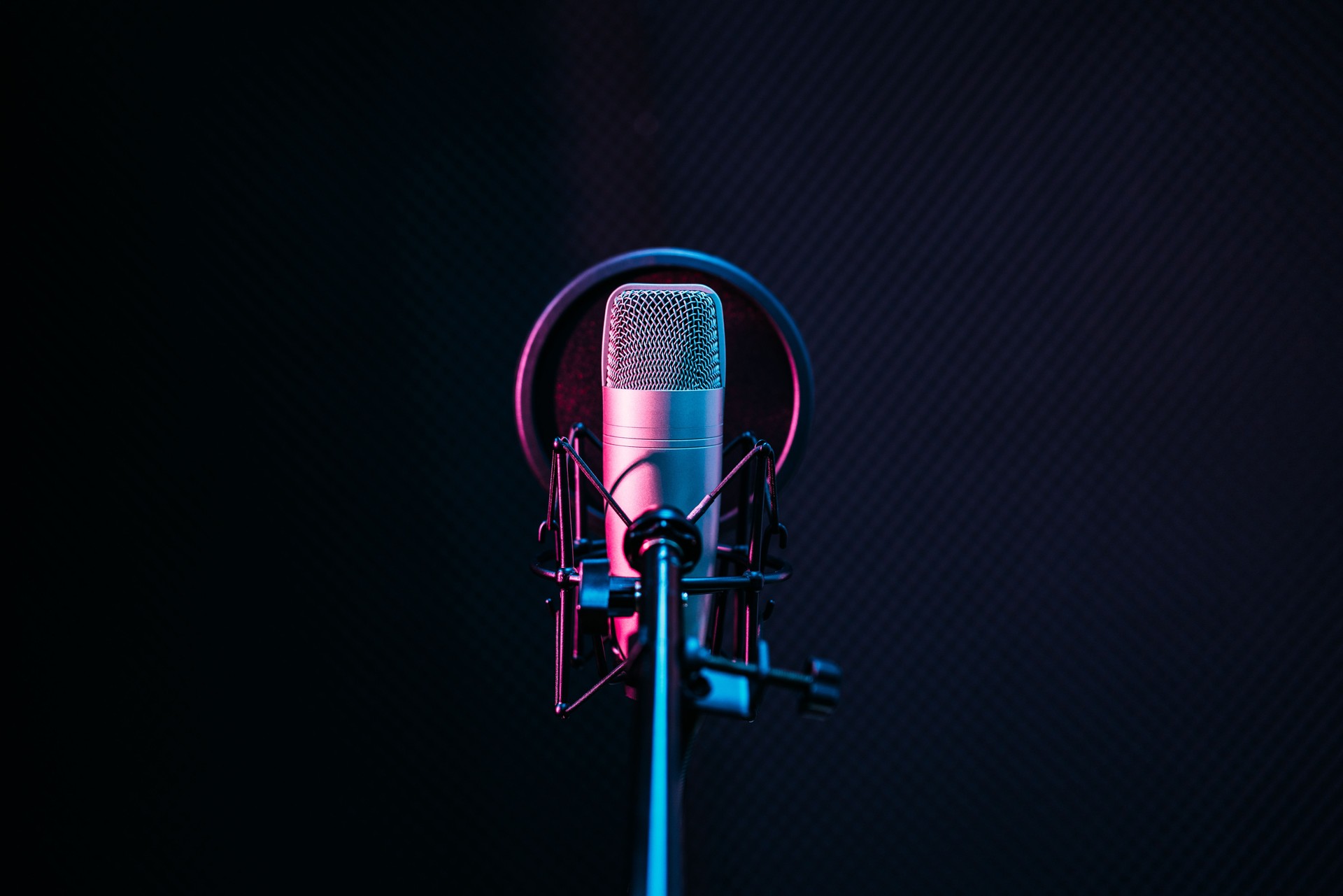 Studio microphone and pop shield on mic in the empty recording studio with copy space. Performance and show in the music business equipment.